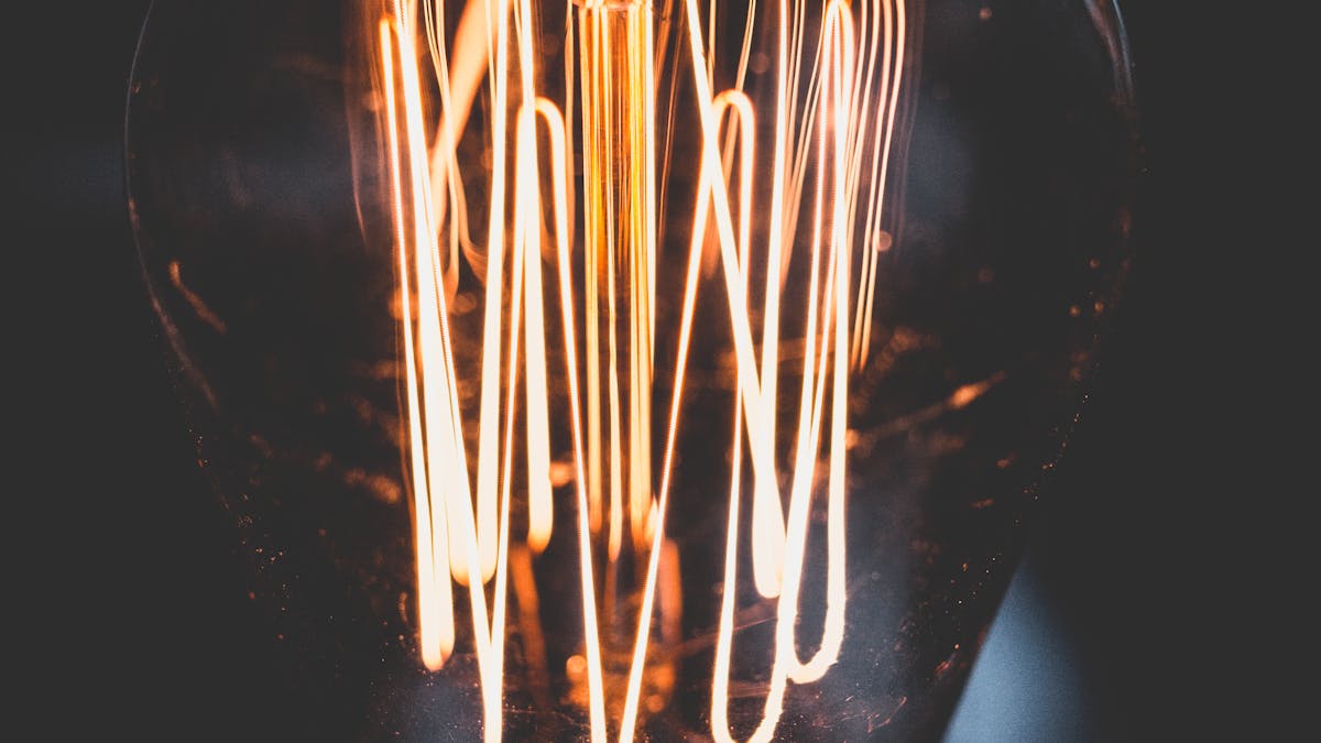 Gros plan d'une ampoule à filament incandescent allumée
