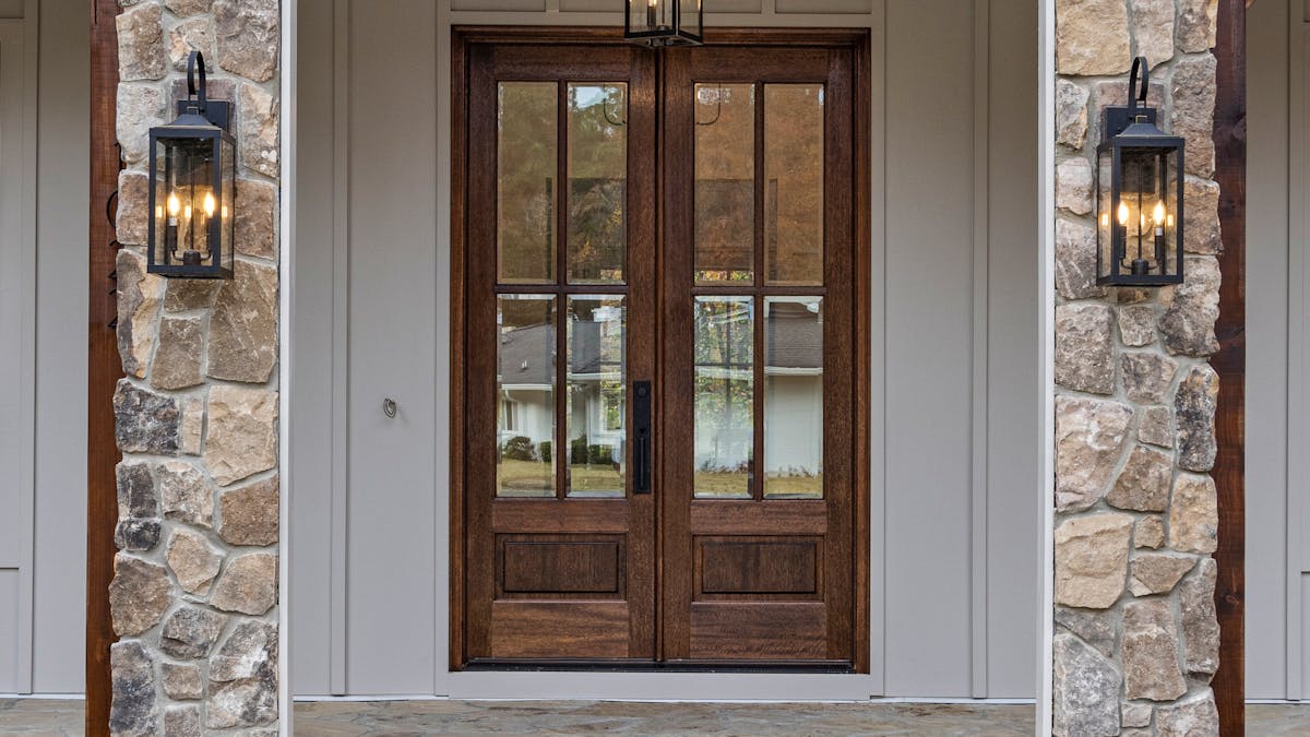 Applique extérieure et lanterne éclairant l'entrée d'une maison la nuit